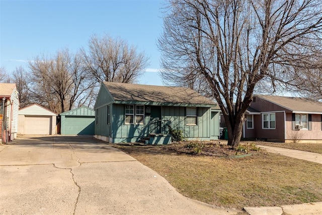 single story home with board and batten siding, an outbuilding, and a detached garage