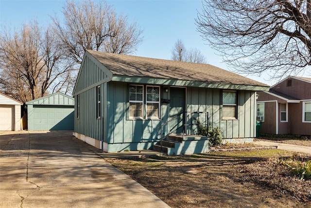 view of front of home featuring an outbuilding, a shingled roof, board and batten siding, and a detached garage