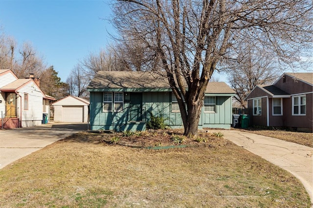 view of front of house with a garage, concrete driveway, an outdoor structure, and board and batten siding