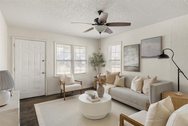 living area with baseboards, a textured ceiling, a ceiling fan, and wood finished floors