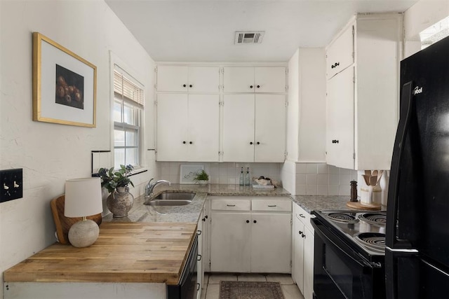 kitchen featuring visible vents, decorative backsplash, black appliances, white cabinetry, and a sink