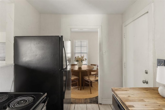 kitchen with wooden counters and freestanding refrigerator