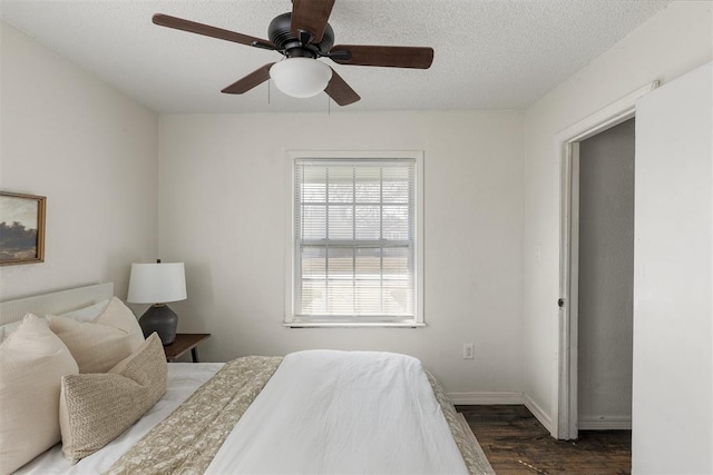 bedroom with a textured ceiling, ceiling fan, wood finished floors, and baseboards