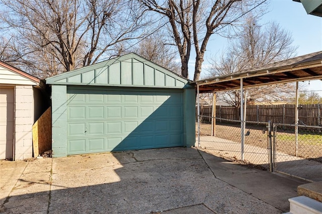 detached garage with a carport and fence