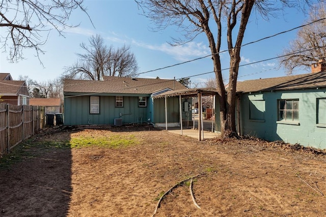 back of house with a patio, central AC unit, board and batten siding, and fence