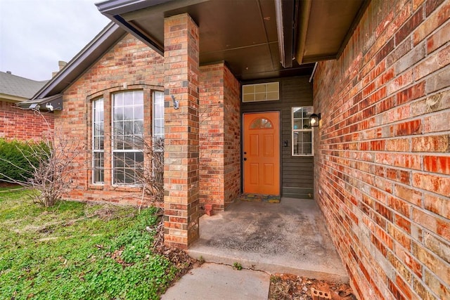 doorway to property featuring brick siding