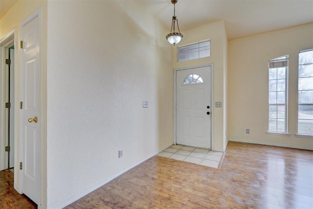 foyer with baseboards and wood finished floors