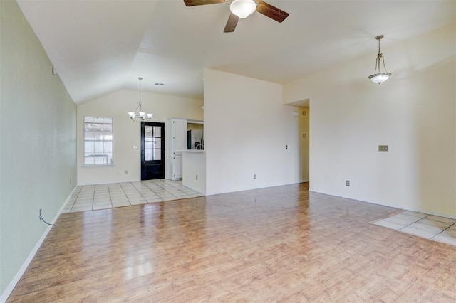 unfurnished living room with lofted ceiling, ceiling fan with notable chandelier, and light wood finished floors