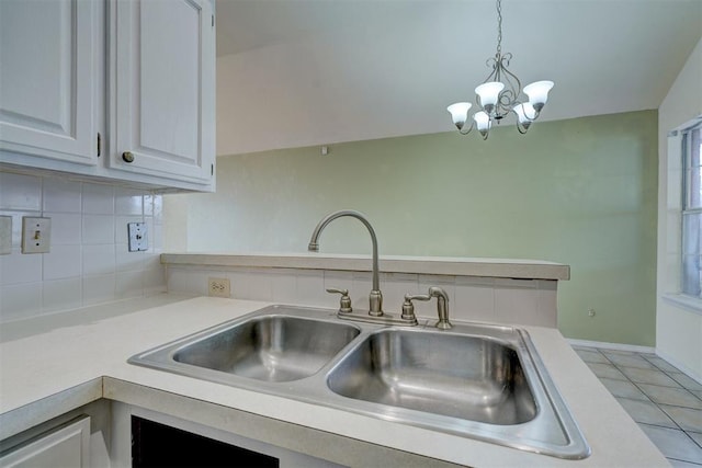 kitchen with tasteful backsplash, light countertops, light tile patterned floors, hanging light fixtures, and a sink