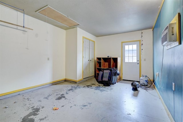 garage with an AC wall unit and baseboards