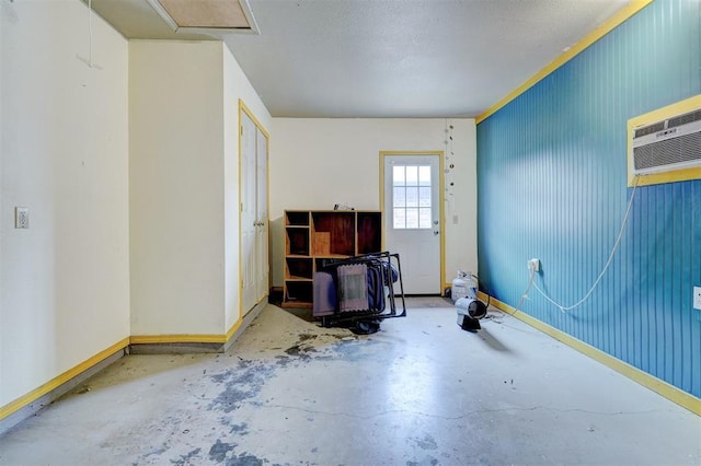 interior space with an AC wall unit, baseboards, and concrete floors