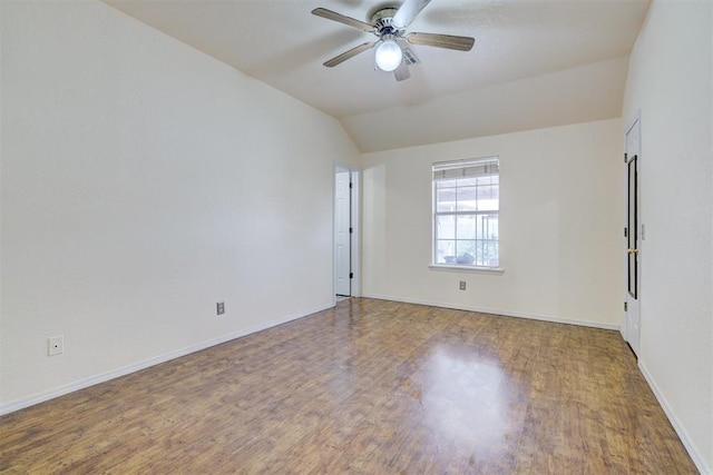 spare room featuring ceiling fan, baseboards, wood finished floors, and vaulted ceiling