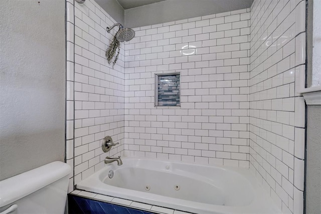 bathroom with a textured wall, toilet, and a combined bath / shower with jetted tub