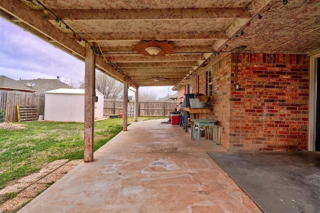 view of patio with an outbuilding, a fenced backyard, a shed, and ceiling fan