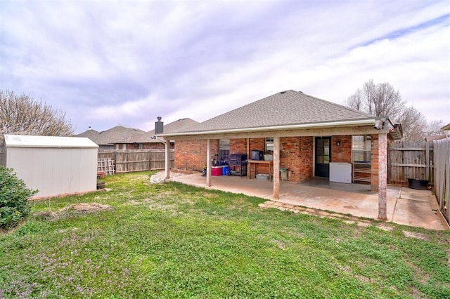 rear view of property featuring a storage unit, brick siding, an outdoor structure, and a patio area