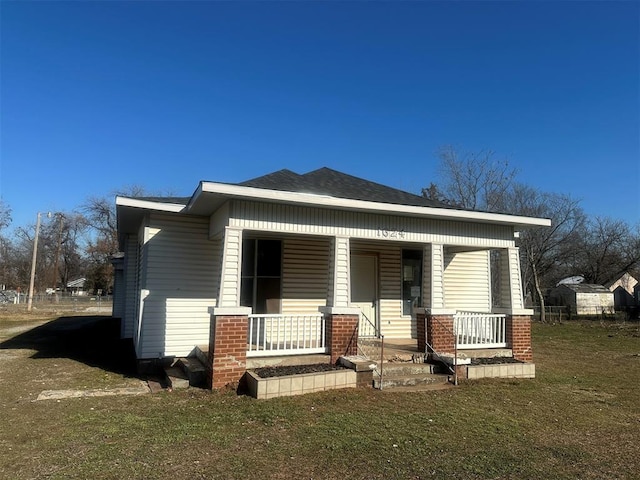 view of front of home featuring covered porch and a front yard