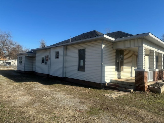 view of home's exterior with covered porch and roof with shingles