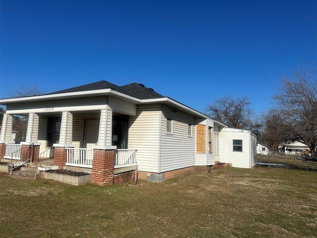 view of home's exterior with a porch and a lawn