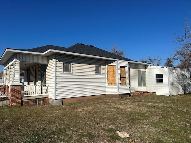 back of house with covered porch and a shingled roof