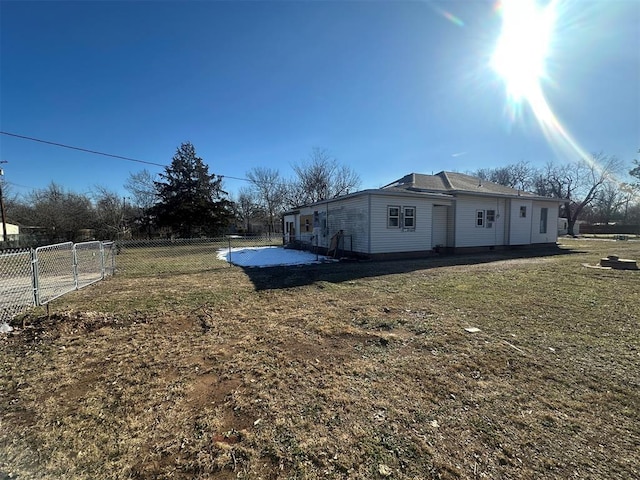 view of property exterior with a yard, a gate, and fence