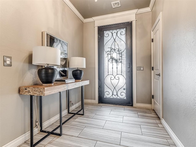 entrance foyer with baseboards, a textured wall, visible vents, and crown molding