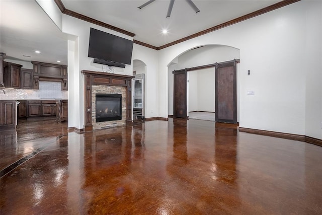 3520 SW 123rd Pl, Oklahoma City, OK 73170 - unfurnished living room featuring ceiling fan, arched walkways, a barn door, a fireplace, and baseboards