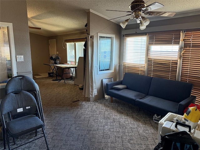 carpeted living area with a ceiling fan, a textured wall, crown molding, and a textured ceiling