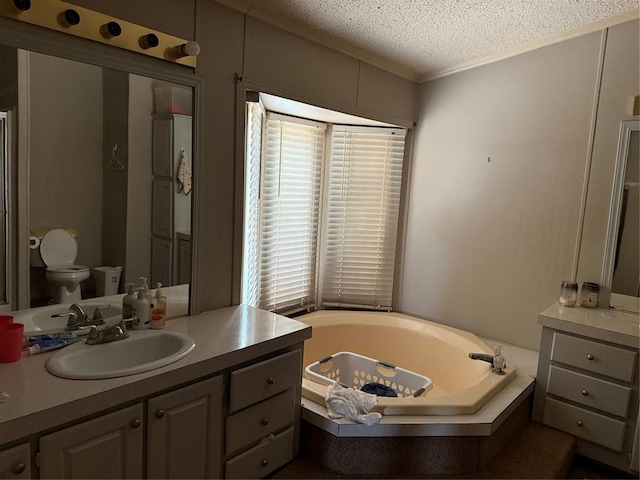 full bathroom with a textured ceiling, toilet, vanity, and a bath