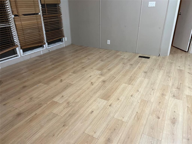 empty room featuring visible vents and wood finished floors