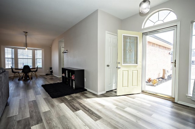 foyer featuring vaulted ceiling, baseboards, and wood finished floors