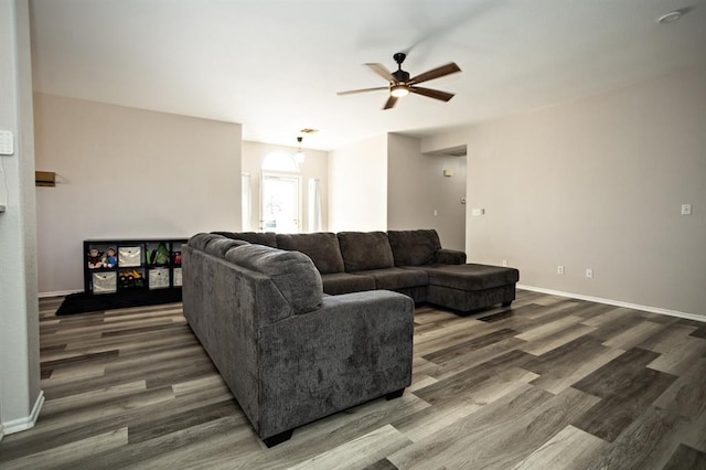 living area featuring ceiling fan, baseboards, and wood finished floors