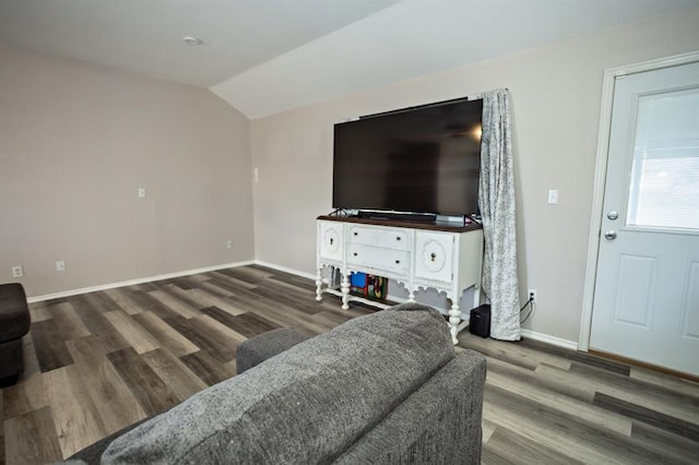 living room featuring lofted ceiling, baseboards, and wood finished floors