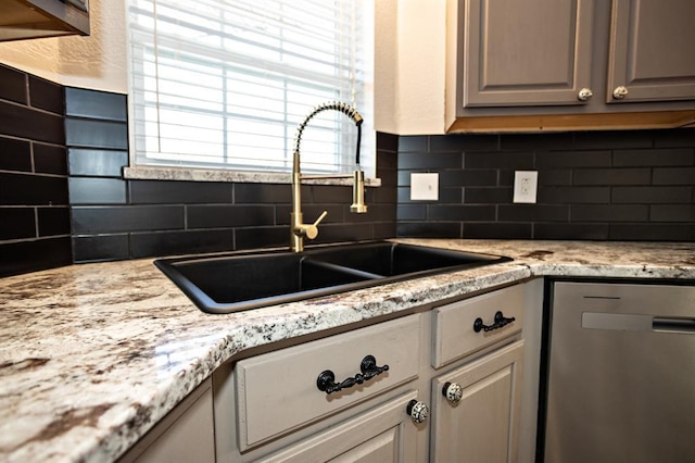 kitchen featuring dishwasher, tasteful backsplash, and a sink