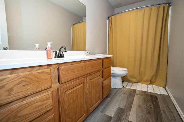 bathroom featuring toilet, wood finished floors, and vanity