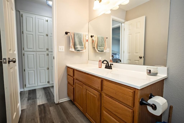 bathroom featuring baseboards, wood finished floors, and vanity