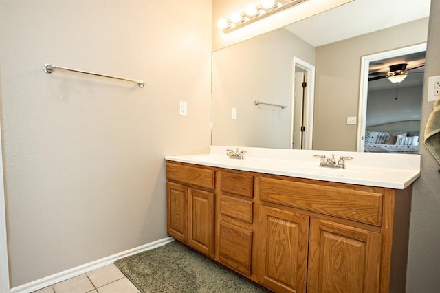 ensuite bathroom featuring double vanity, ensuite bathroom, a sink, tile patterned flooring, and baseboards