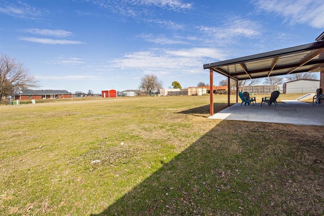 view of yard with fence, an outdoor structure, and a patio