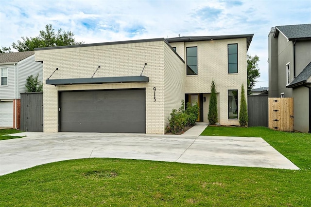 view of front facade with an attached garage, driveway, brick siding, and a front yard