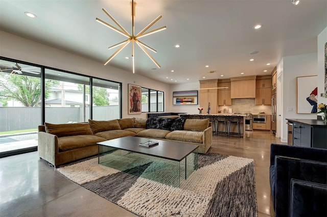 living room featuring finished concrete flooring, a notable chandelier, and recessed lighting