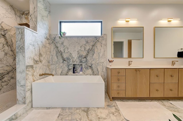 full bathroom featuring a sink, a freestanding bath, marble finish floor, a marble finish shower, and double vanity