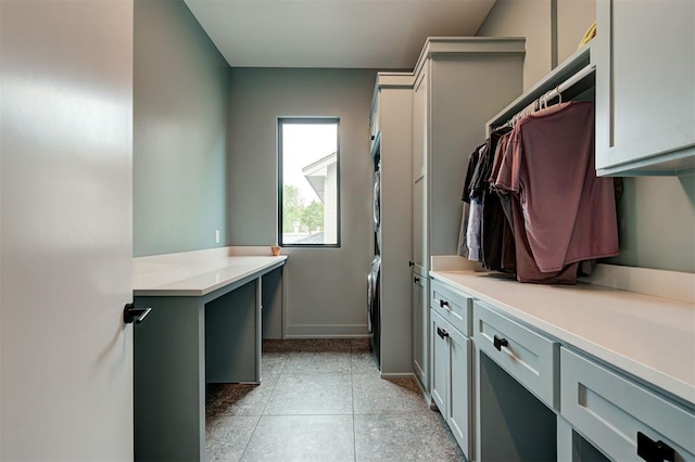 interior space with stacked washer and dryer and baseboards