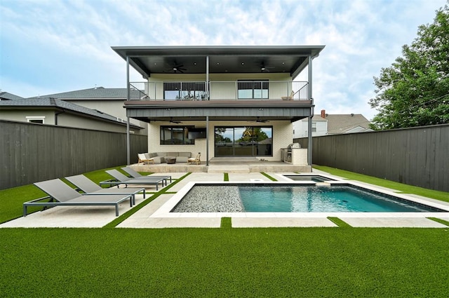 back of house featuring a lawn, an outdoor hangout area, a ceiling fan, a balcony, and a fenced backyard