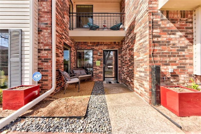 view of exterior entry with a balcony