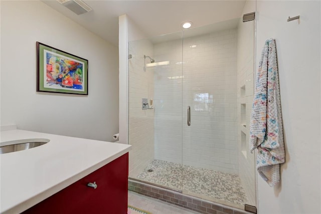 bathroom with a stall shower, visible vents, and vanity