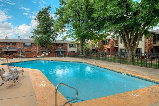 community pool featuring a patio and fence