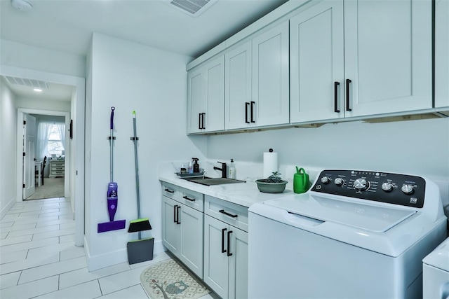 laundry area with light tile patterned flooring, cabinet space, washing machine and clothes dryer, and visible vents