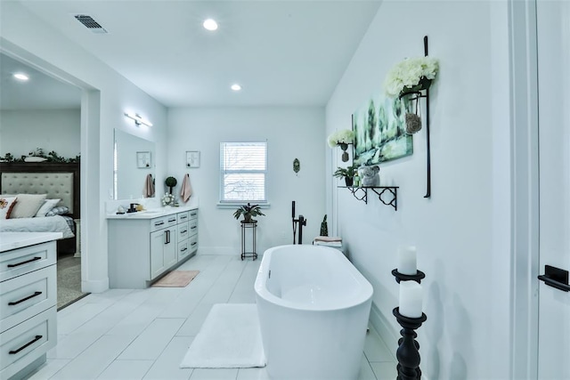 full bathroom featuring a freestanding tub, connected bathroom, recessed lighting, vanity, and visible vents