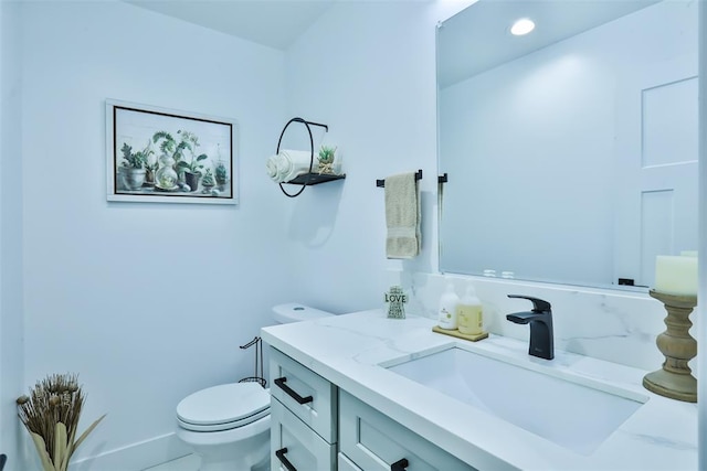 bathroom featuring toilet, recessed lighting, and vanity