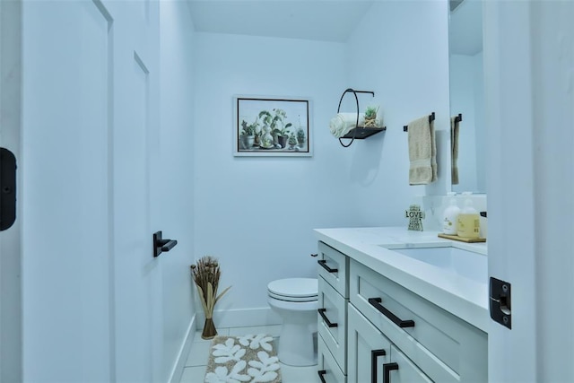 bathroom with baseboards, vanity, toilet, and tile patterned floors