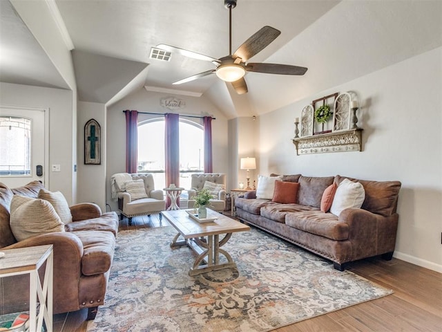living room featuring a ceiling fan, baseboards, wood finished floors, vaulted ceiling, and visible vents